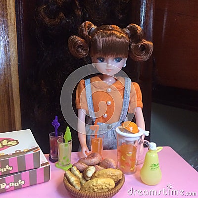Adorable doll is making orange juice. Editorial Stock Photo